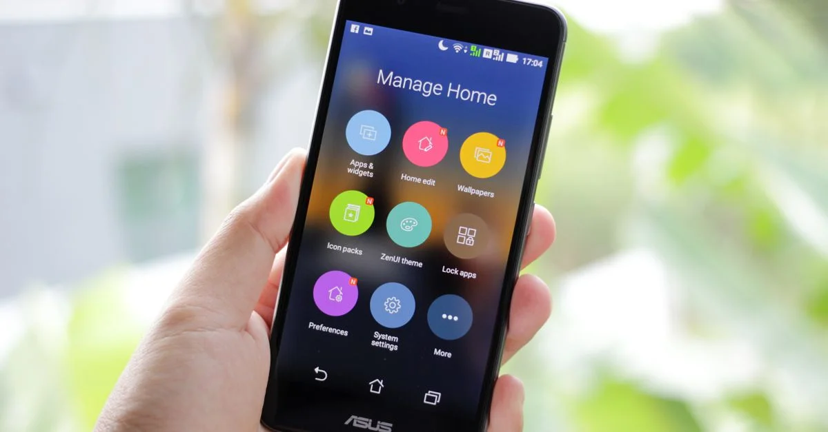 Une main tenant un smartphone affichant des applications de gestion de la maison à l'écran.