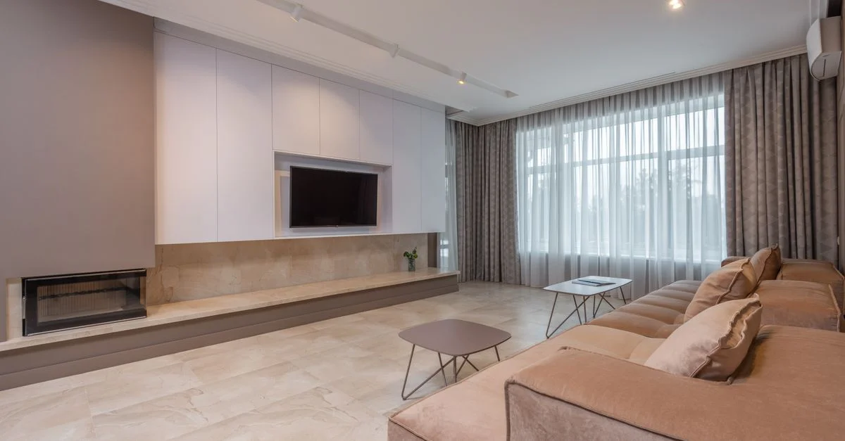 Salon moderne spacieux avec décor beige, grand canapé et style minimaliste.