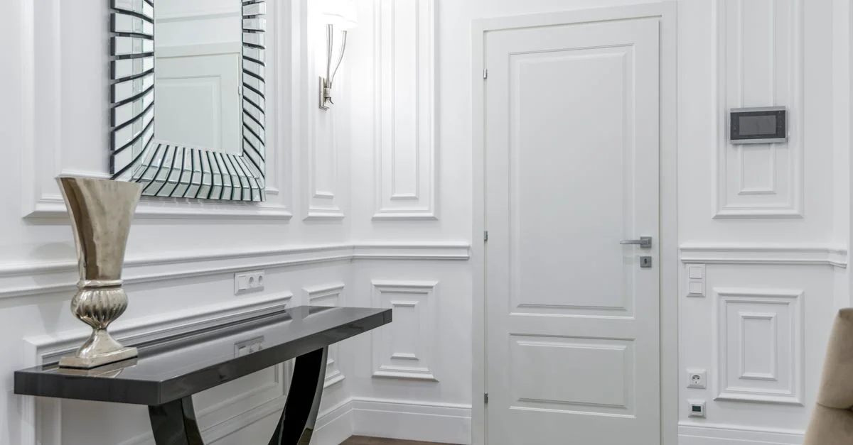 Intérieur luxueux blanc avec une décoration moderne, comprenant un miroir élégant et une porte raffinée.