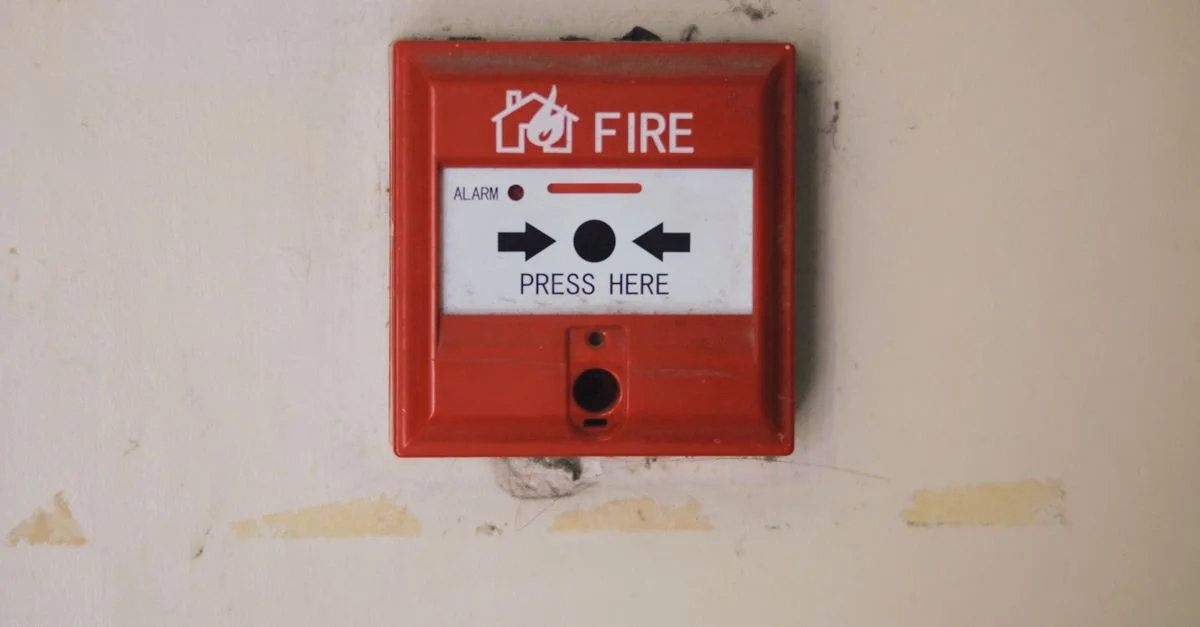 Vue rapprochée d'une boîte d'alarme incendie rouge sur un mur intérieur, mettant en avant la sécurité.