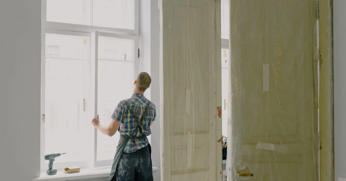 Un homme à tout faire travaillant sur l'installation de fenêtres à l'intérieur pendant la rénovation de la maison.