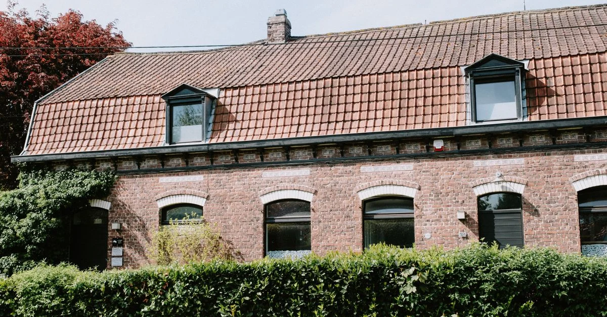 Joli maison en briques avec des fenêtres de lucarne et des lierres sur la façade à Lille, France. Capture l'architecture traditionnelle.