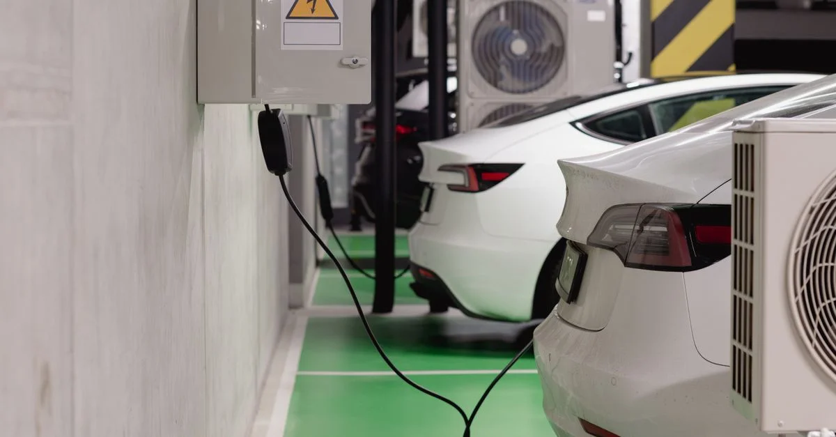 Véhicules électriques en charge à une station intérieure dans un garage souterrain moderne.