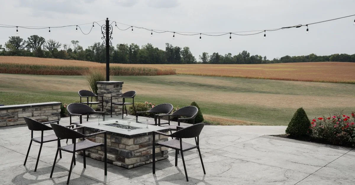 Charmante terrasse extérieure avec sièges et vue sur la campagne environnante, idéale pour se détendre.